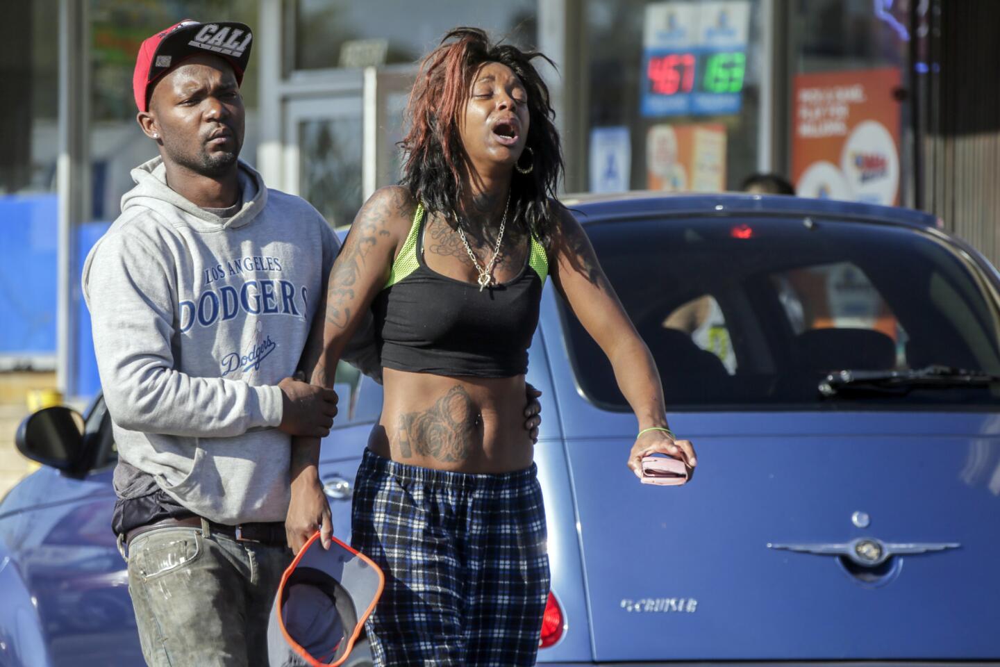 Grieving stepfather Leonard Grant, 27, left, and Ebony Newman, 27, mother of 9-year-old Travon Williams in front of the liquor store where the shooting occurred.