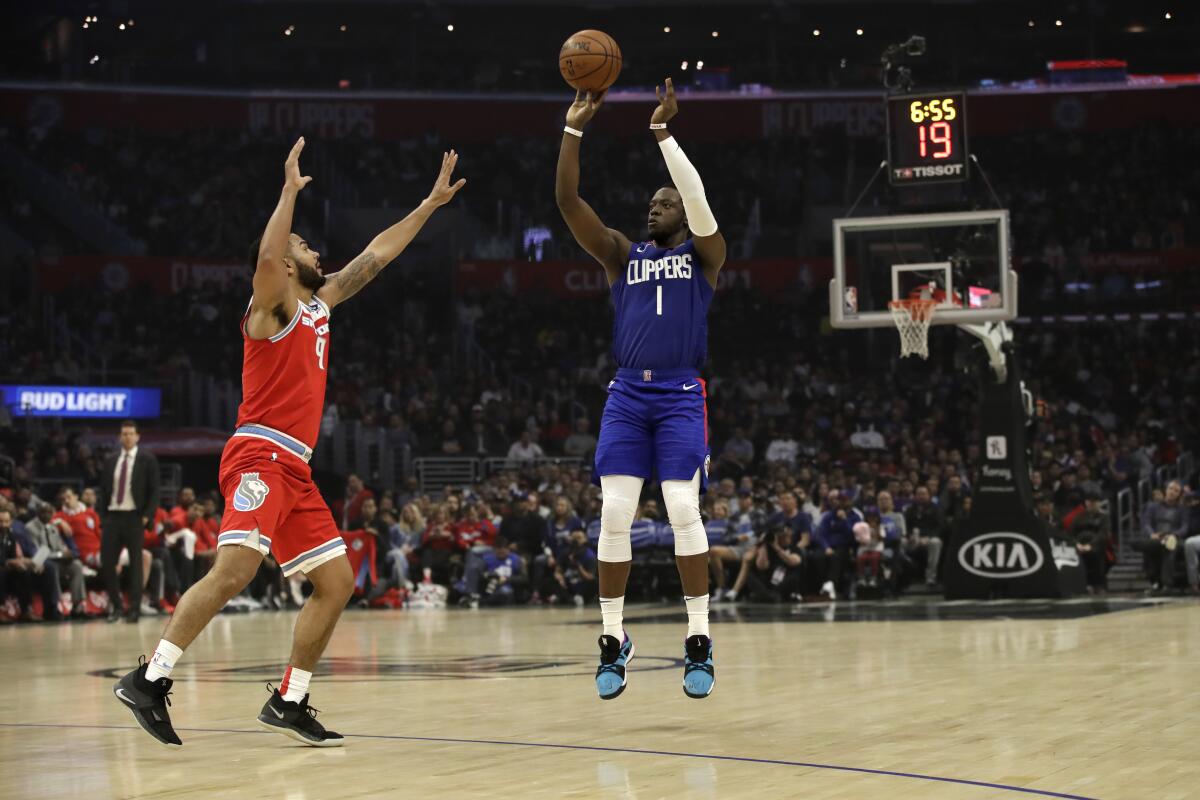Clippers' Reggie Jackson, right, shoots over the Sacramento Kings' Cory Joseph.