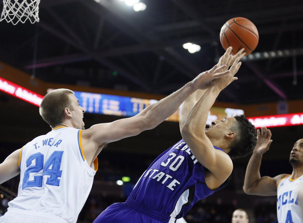 UCLA's Travis Wear, left, tries to block a shot by Weber State's Jeremy Senglin during the Bruins' 83-60 win Sunday. UCLA Coach Steve Alford says he's not necessarily committed to a single defensive strategy.