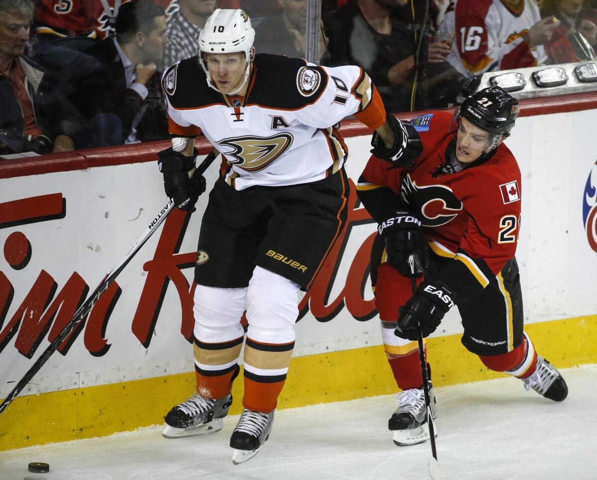 Ducks right wing Corey Perry (10) works along the boards against Flames left wing Mason Raymond during a game March 11.