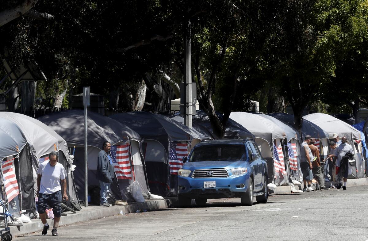  American flags decorate tents at an encampment of homeless people along San Vicente Boulevard in Brentwood in July 2020.