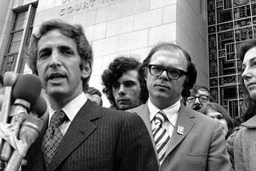 As his co-defendant, Anthony Russo (right) listens, Daniel Ellsberg tells newsmen outside the Federal Building in Los Angeles, Ca. on Jan. 17 1973 that the Pentagon Papers trial prosecuters were acting out "their contempt for the American people" by placing a movie screen between the trial principals and the press and public, seated at the back of the courtroom. The Judge ordered the screen removed and replaced by a smaller one along the wall. (AP Photo/stf)