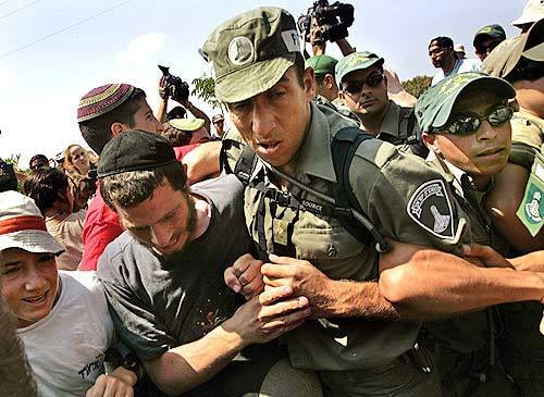 Israeli police struggle with protesters blocking the road to the settlement of Neve Dekalim.