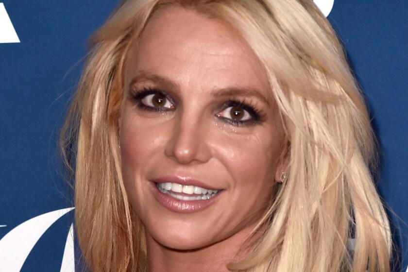 The face of a blond woman wearing dark eye makeup