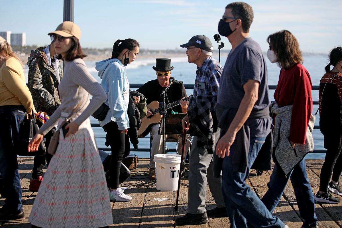 Robert sings and plays the guitar on the pier in Santa Monica.