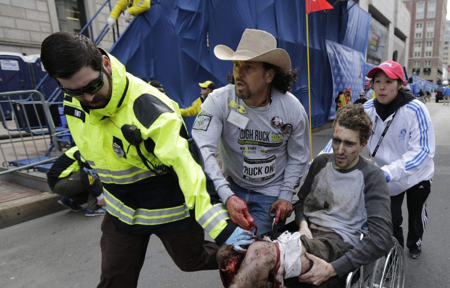 Emergency responders and volunteers push Jeff Bauman in a wheel chair after he was injured in an explosion near the finish line of the Boston Marathon.