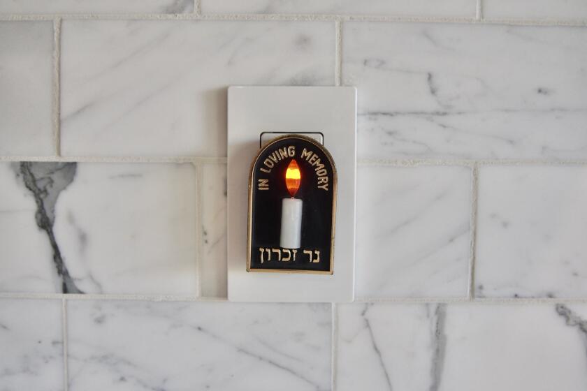 An electric Yahrzeit candle inscribed with the words "In Loving Memory" in both English and Hebrew.