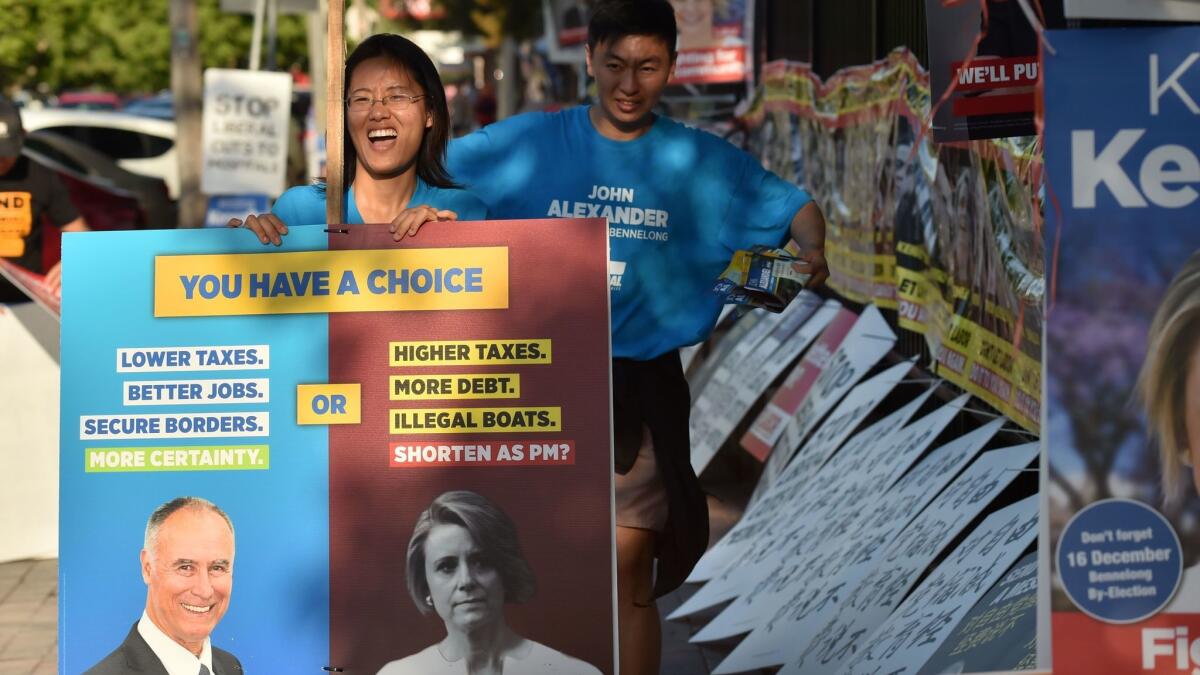 Supporters of Liberal Party candidate John Alexander pack away banners outside a polling station at the close of voting in the suburban Sydney seat of Bennelong on Dec. 16, 2017.