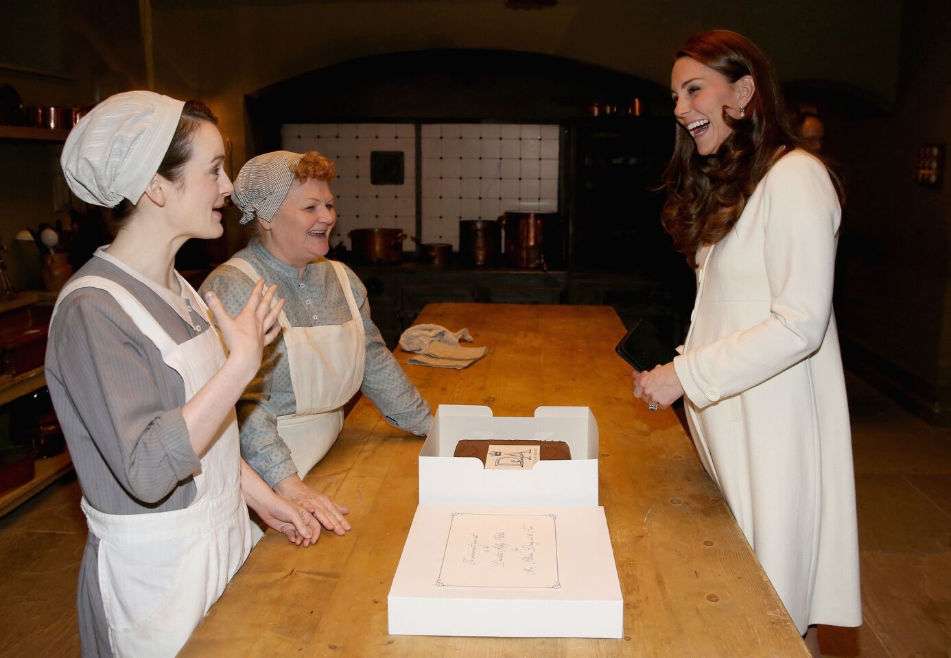 The duchess visits Downton's kitchens and speaks with actresses Sopie McShera, right, and Lesley Nicol, center, who play kitchen servants Daisy and chef Mrs. Patmore, respectively