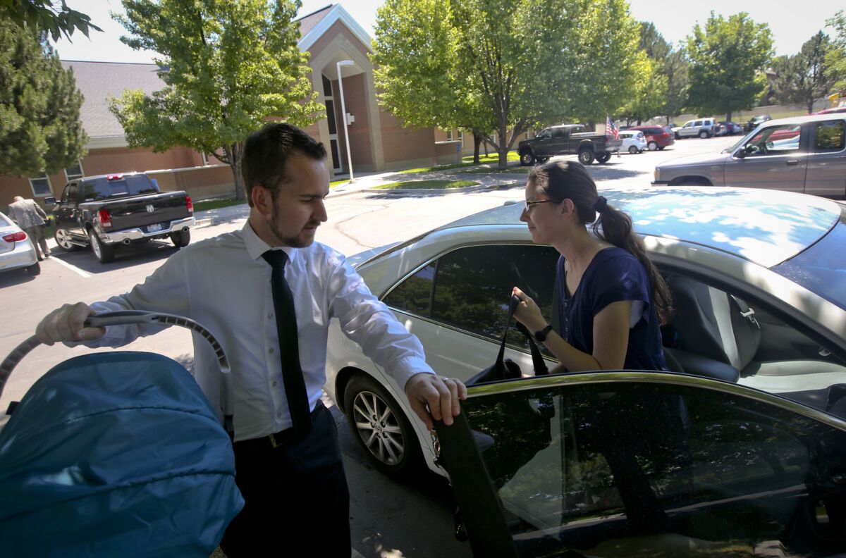 Stoll opens the car door for Rachael as he carries Everly before attending a church service at a LDS meeting house in West Jordan, Utah.
