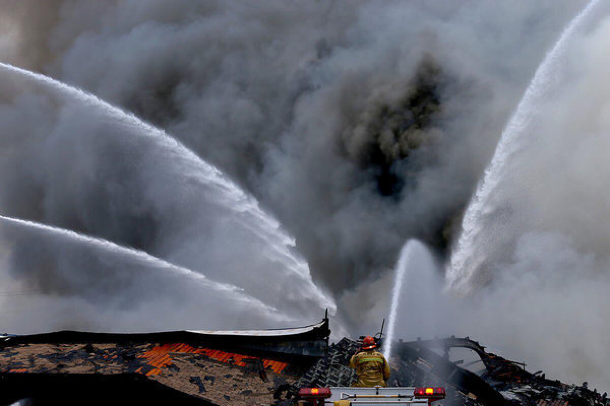 Smoke billows from an abandoned food processing plant in industry, where firefighters battled a three-alarm fire blaze.