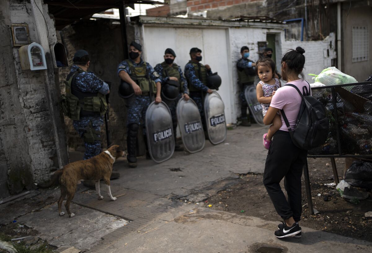 Riot policemen stand guard during an operation in the Villa Sarmiento shanty town in Buenos Aires, Argentina, Thursday, Feb. 3, 2022, where it is believed people may have purchased contaminated cocaine. A batch of cocaine that has killed at least 20 people in Argentina appears to have been laced with a synthetic opioid, and police are scrambling to get as much of it off the streets as they can. (AP Photo/Rodrigo Abd)