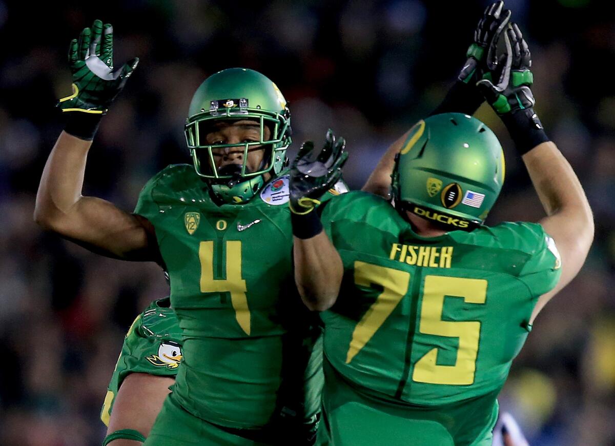 Ducks defensive back Erick Dargan celebrates with offensive lineman Jake Fisher after intercepting a pass in the third quarter.