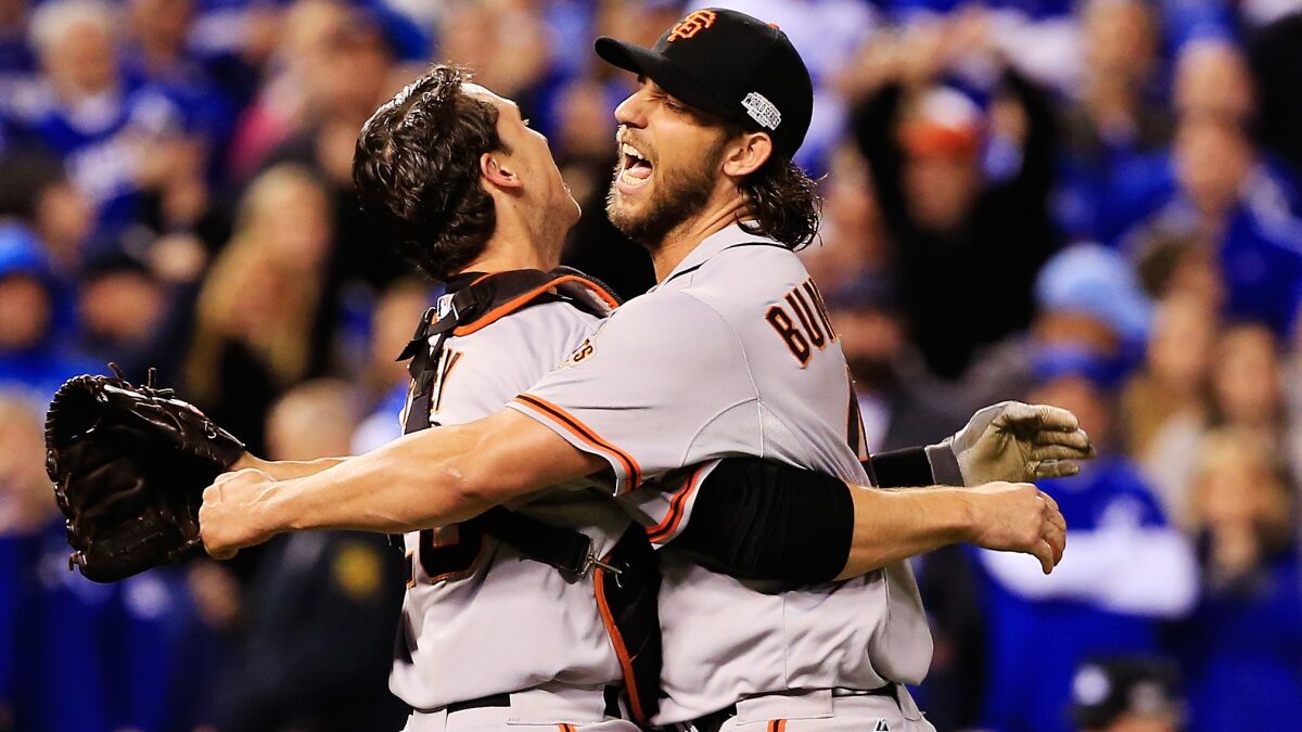 San Francisco Giants catcher Buster Posey, left, celebrates with pitcher Madison Bumgarner following a 3-2 victory over the Kansas City Royals in Game 7 of the World Series.