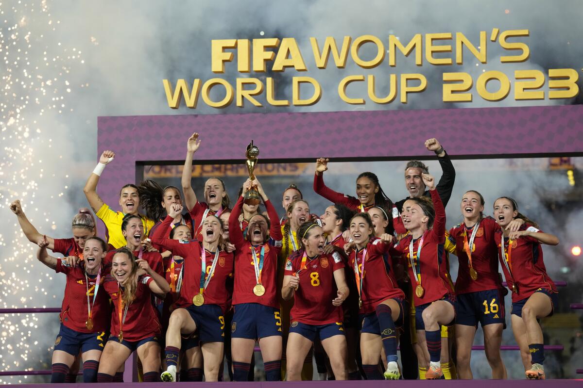 Spain's players stand on a podium, lift the World Cup trophy and celebrate as fireworks are set off around them