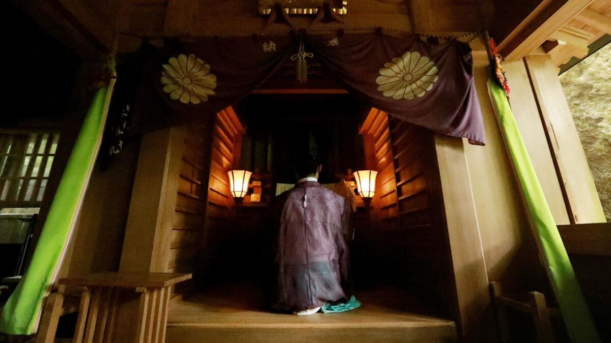 A Shinto priest holding a ritual ceremony at Okitsugu shrine of the Munakata Taisha on Japan's Okinoshima island.