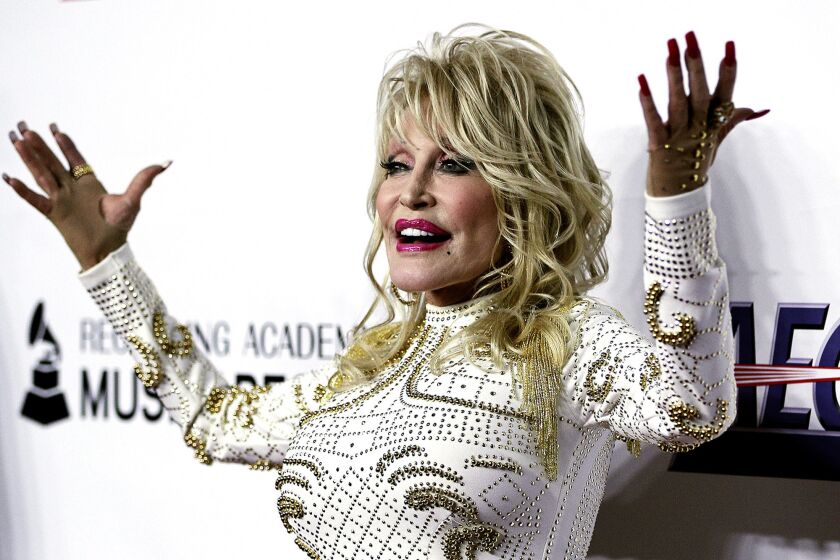Dolly Parton poses for photographers on the red carpet as she arrives as the honoree for MusiCares' Person of the Year 2019.