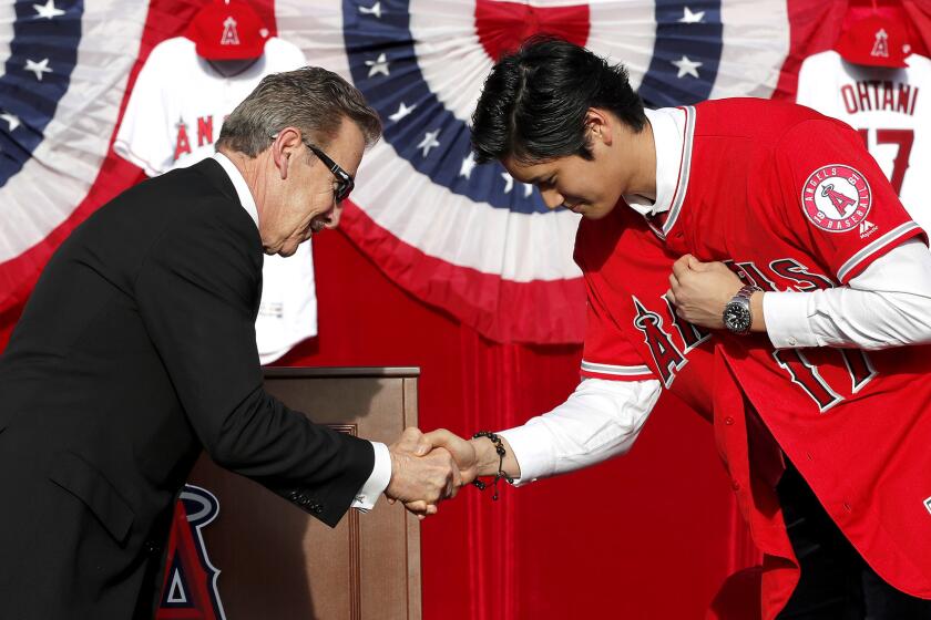 ANAHEIM, CALIF. -- SATURDAY, DECEMBER 9, 2017 Arturo "Arte" Moreno, left, bows and congratulates Japanese superstar Shohei Ohtani, who is the Angels newest pitcher and a power hitter, during a press conference at Angel Stadium in Anaheim, Calif., on Dec. 9, 2017. (Allen J. Schaben / Los Angeles Times)