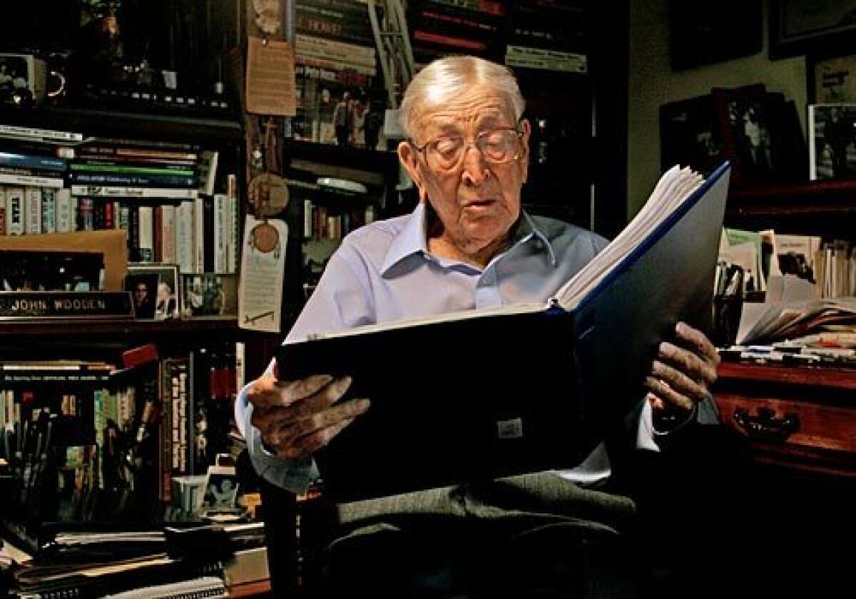 Wooden, at his Encino home, reads from an assembled book of poems sent to him by one of his former players, Swen Nater. See full story