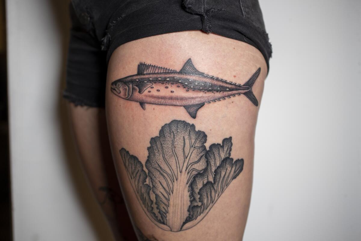 A view of Sydney Kramer's latest tattoo, a Spanish mackerel, top, and Napa cabbage, both by tattoo artist Emily Kay.