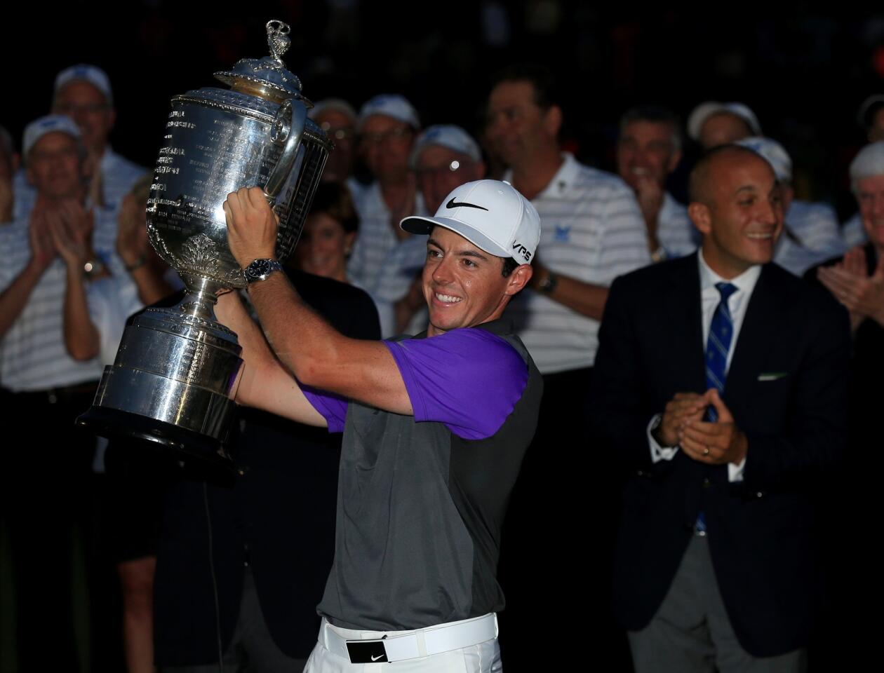 Rory McIlroy hoists the Wanamaker Trophy after winning the PGA Championship at dusk on Sunday at Valhalla Golf Club.