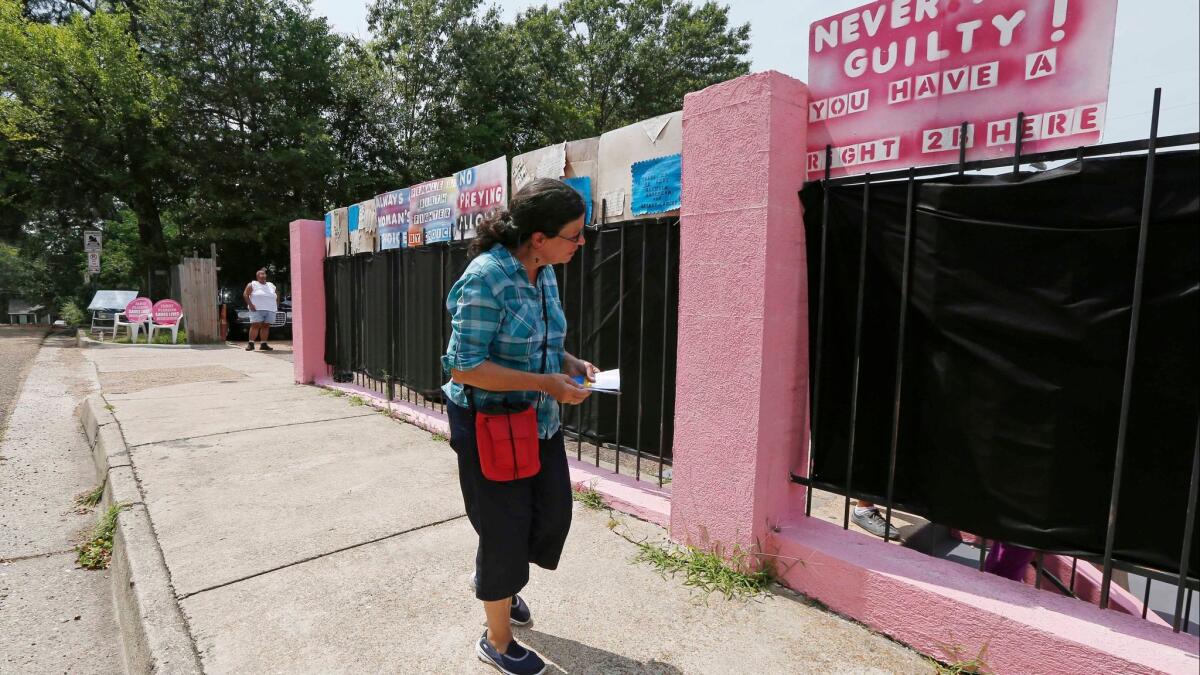 Pam Miller, of Pro Life Mississippi, walks along the fence surrounding the Jackson Women's Health Organization clinic near downtown Jackson, Miss. in 2015. The facility is the only legal abortion clinic in the state.