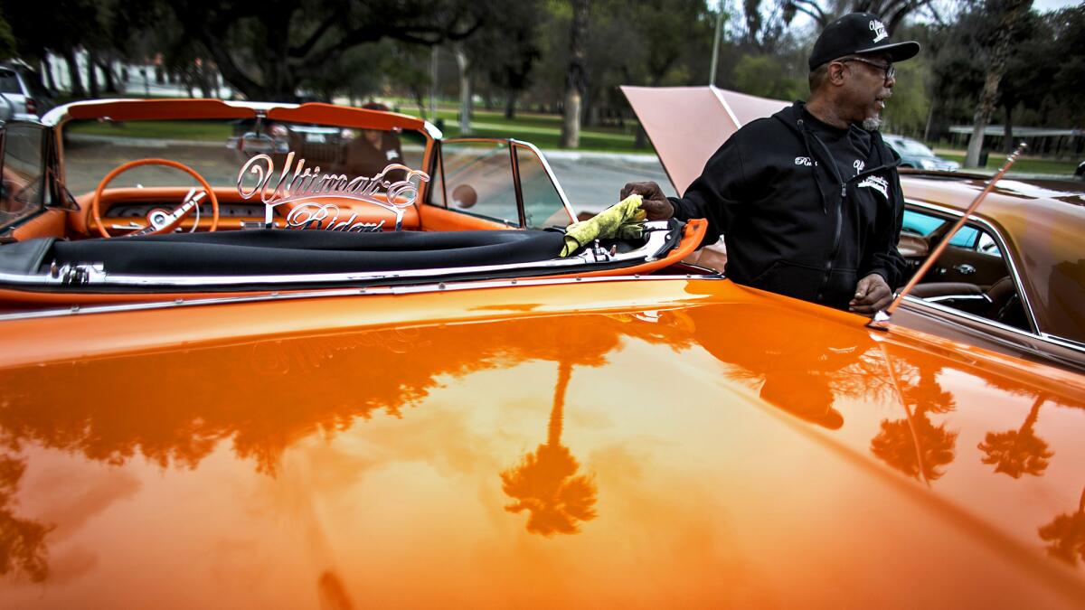 Russell Rudolph shines a 1963 Impala during a meeting of the Ultimate Riders Car Club at Fairmount Park.