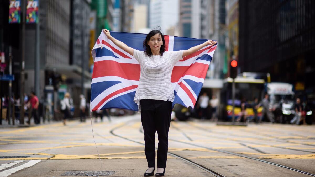 In this picture taken on May 18, 2017, artist and designer Alice Lai, 39, who heads a small protest group called HK-UK Reunification Campaign, holds the British flag on a main road in Hong Kong.