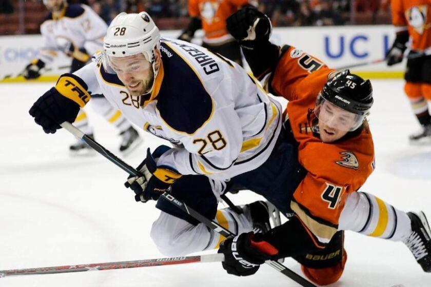 Sabres center Zemgus Girgensons and Ducks defneseman Sami Vatanen get tangled up as they compete for the puck during the first period of a game on March 17 at Honda Center.