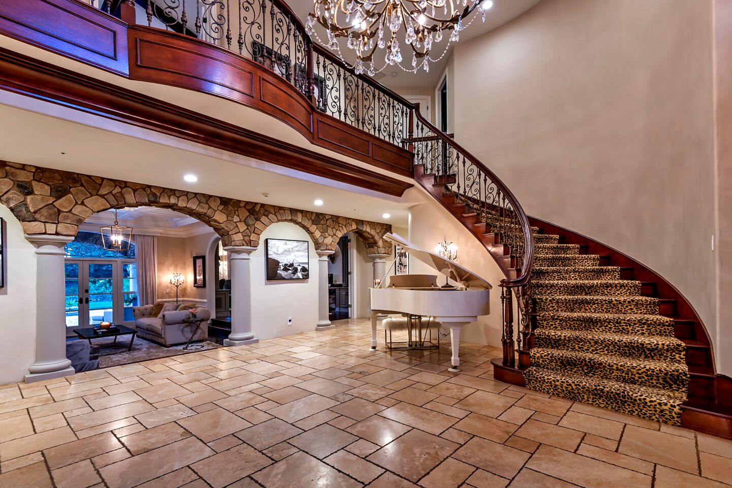 A chandelier and sweeping staircase anchor the two-story foyer.
