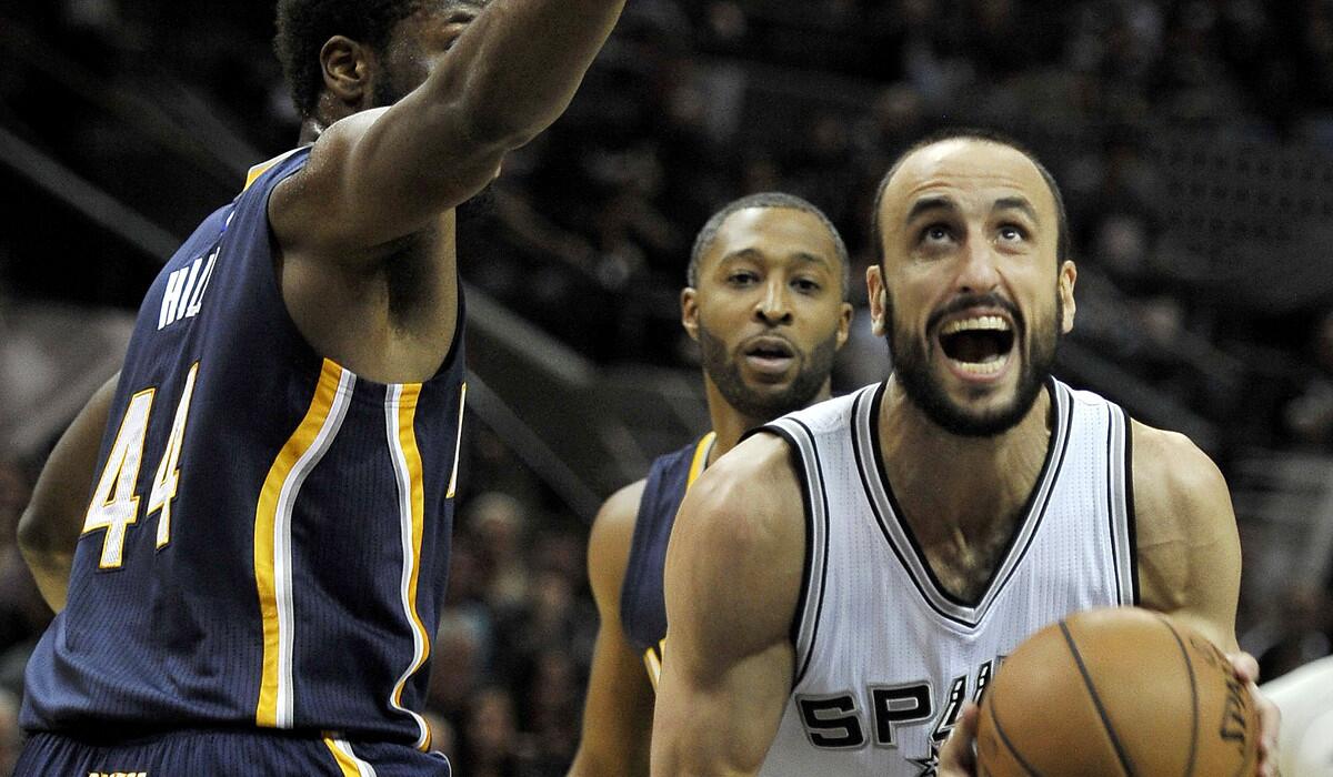 Spurs guard Manu Ginobili slips past Pacers forward Solomon Hill for a layup in the first half Wednesday night in San Antonio.
