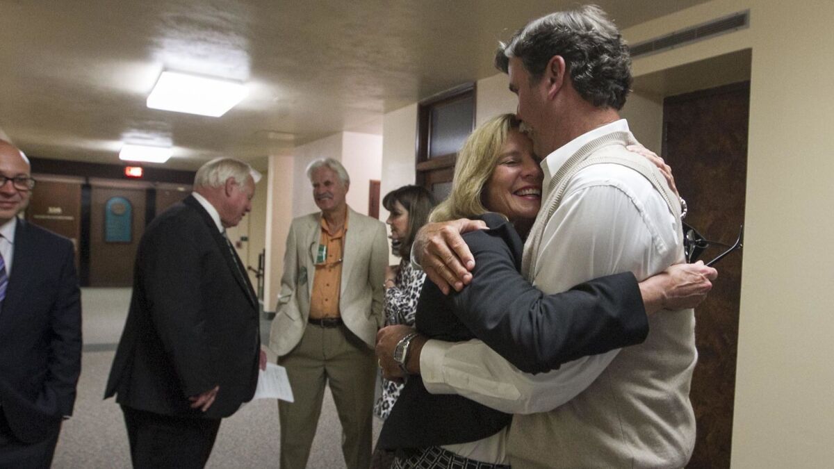 Rita Brandin, senior vice president and development director for Newland Communities, gets a hug from her husband Erik Brandin in the hallway outside of the San Diego County Board of Supervisor's chambers. Her Newland Sierra housing development was approved by a 4-0 vote.