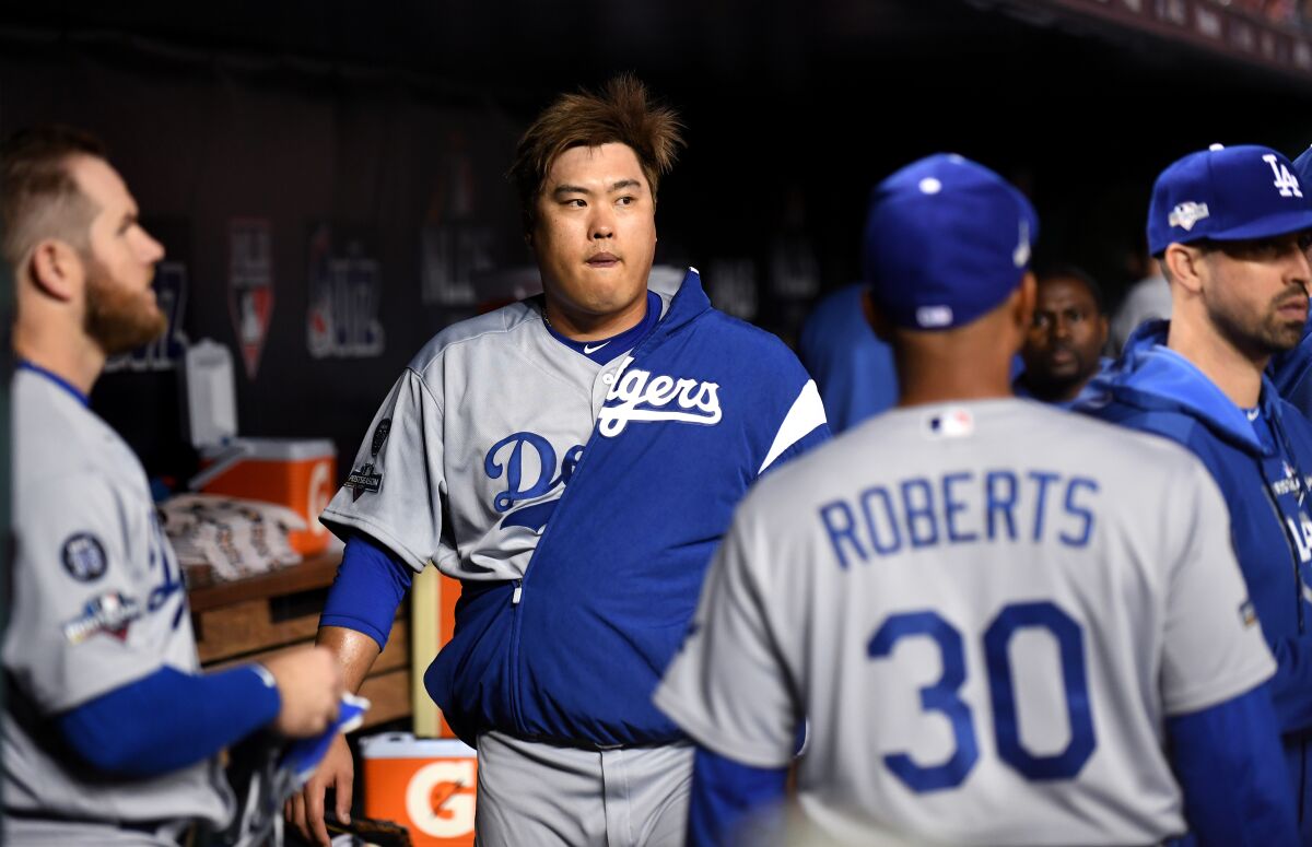 Dodgers pitcher Hyun-Jin Ryu walks in the dugout.