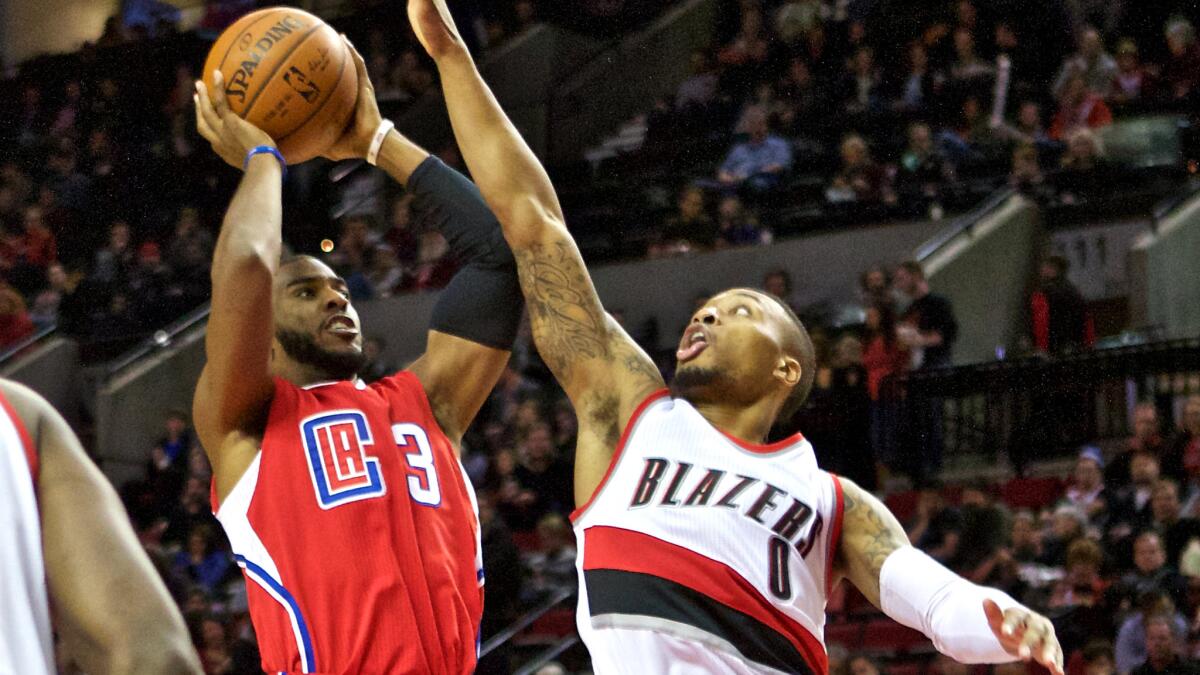 Clippers point guard Chris Paul tries to score over Trail Blazers point guard Damian Lillard in the second half Friday night.