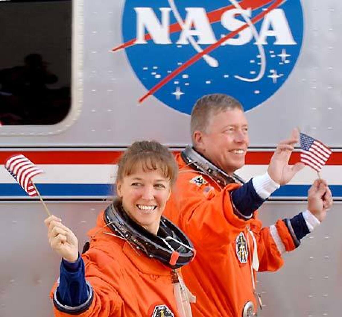 Space Shuttle Discovery mission specialists Lisa Nowak, left, and Michael Fossum make their way to the shuttle in 2006.