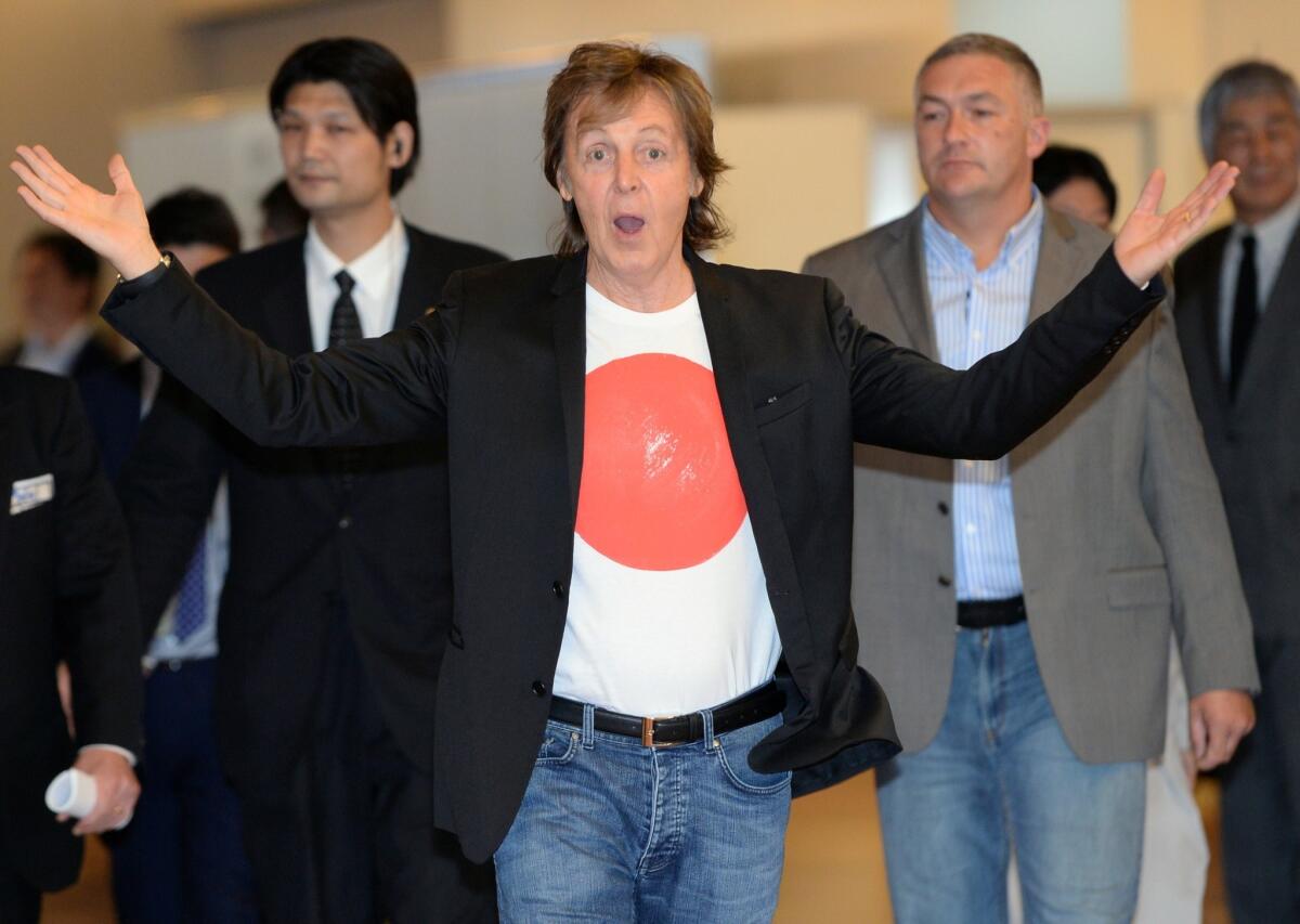 Paul McCartney greets fans and journalists upon his arrival at the Haneda airport in Tokyo on May 15.