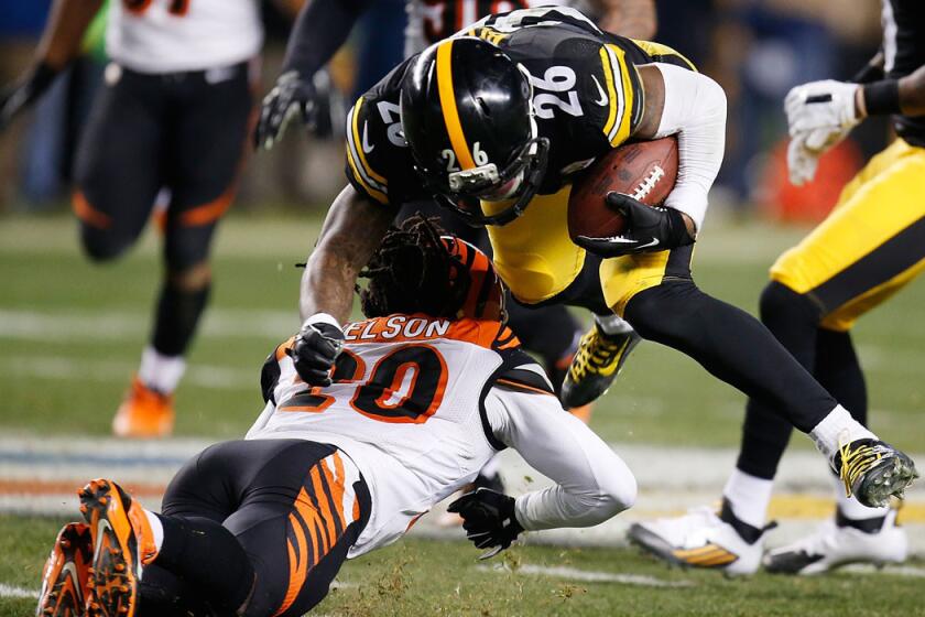 Steelers running back Le'Veon Bell is upended, and injured, when getting tackled by Bengals defensive back Reggie Nelson after picking up a first down on a reception in the third quarter Sunday night.