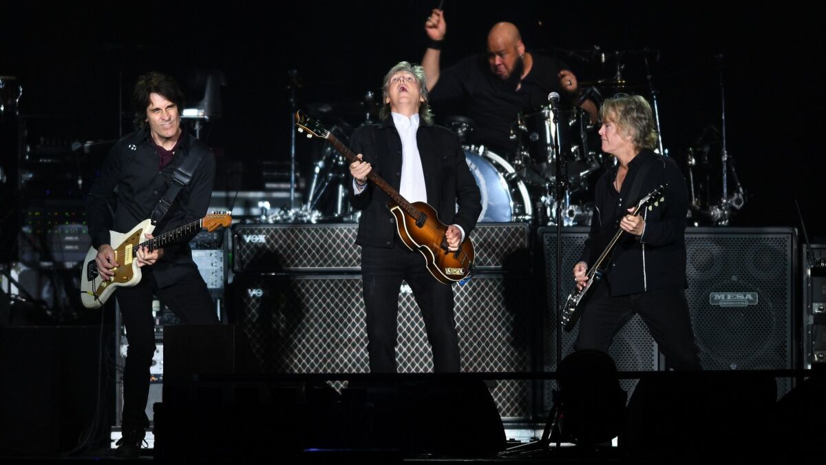 Paul McCartney, center, performs with his band to a sold-out crowd at Dodger Stadium Saturday.