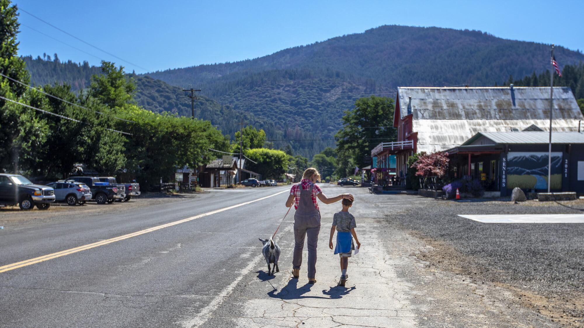 Kjessie Essue and her son, Hugo, walk with their Nigerian Dwarf dairy goat walk home