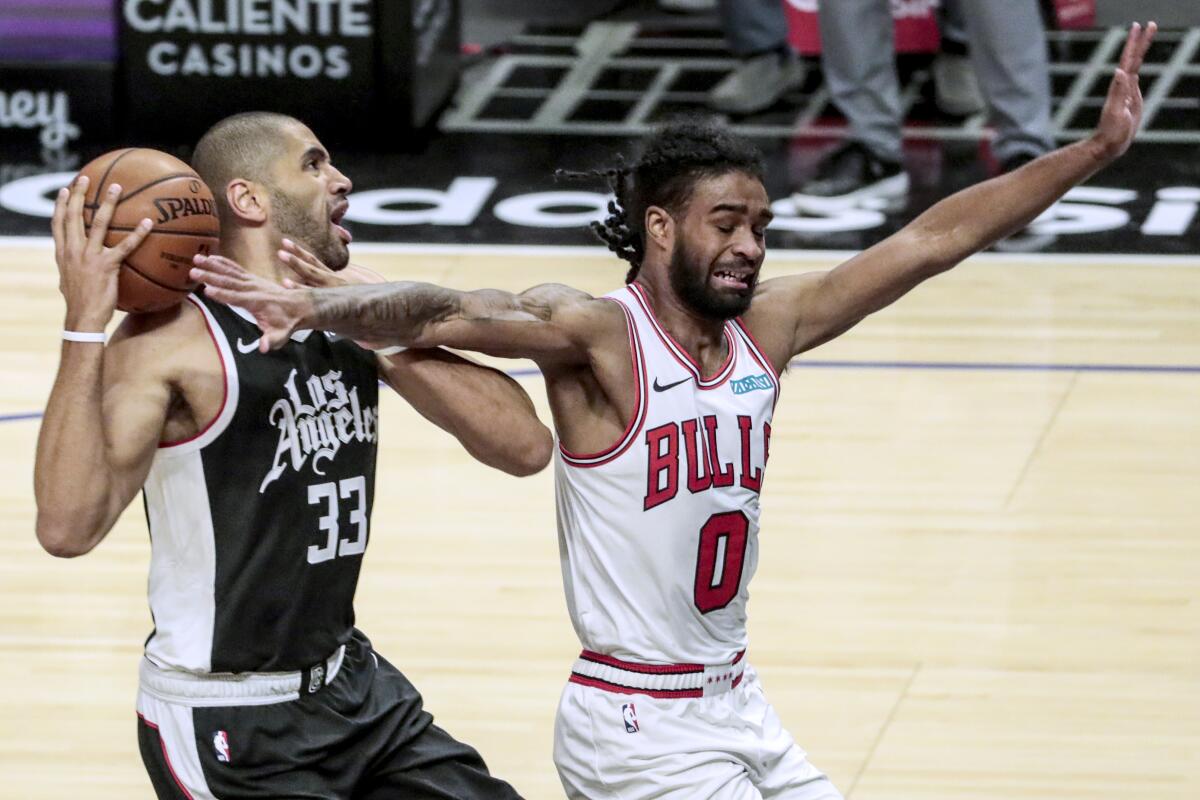 Clippers forward Nicolas Batum is fouled by Bulls guard Coby White during a game Jan. 10, 2020, at Staples Center.