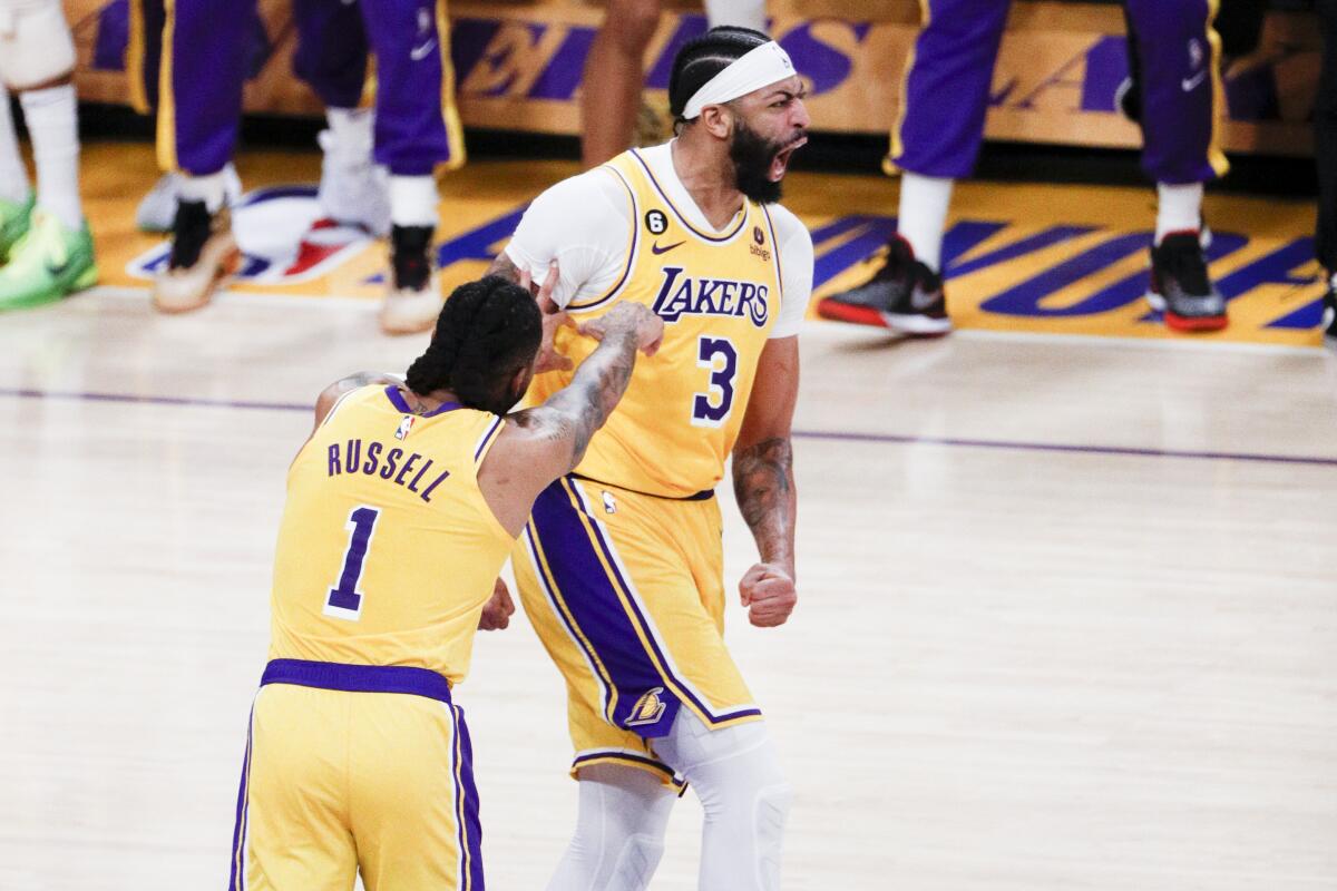 Lakers forward Anthony Davis, right, lets out a yell while celebrating a play with teammate D'Angelo Russell.