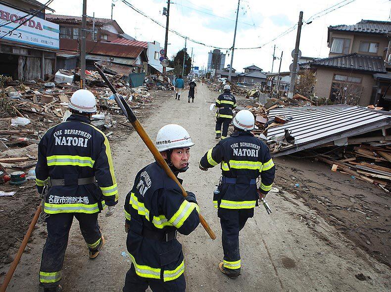 Firefighters patrol the streets of Natori, where hundreds of homes were swept away.