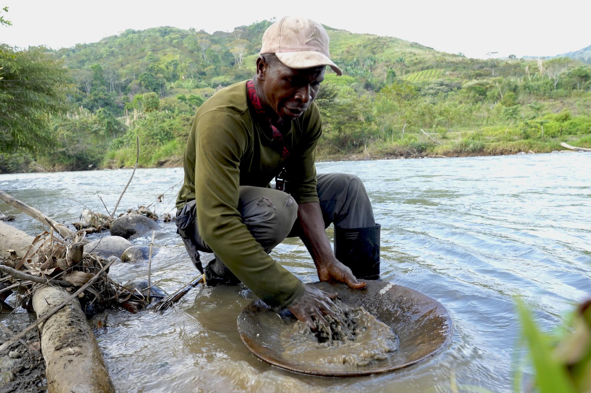 A man pans for gold in a river 