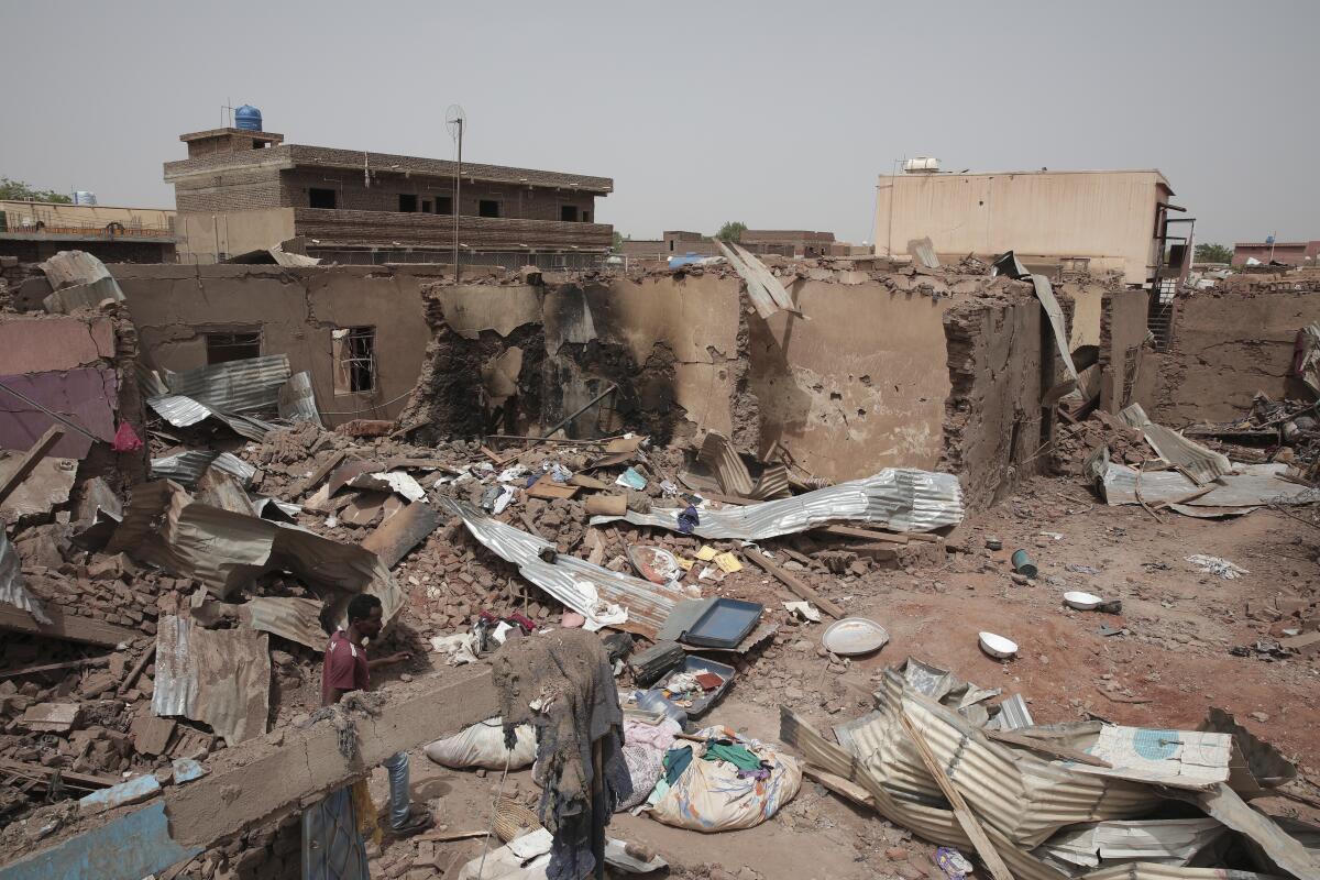 A man walks by a damaged house in Khartoum, Sudan.