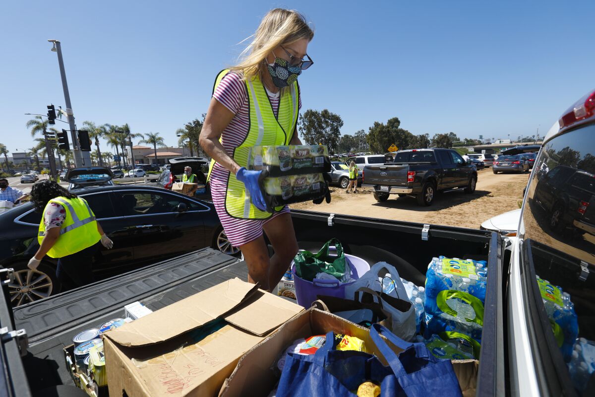 SANDAG estimates one in four San Diego County workers are now unemployed. Pictured: Caroline Thiss-Aird loads the back of her truck of donated items during donation food drive in Carlsbad on April 25.