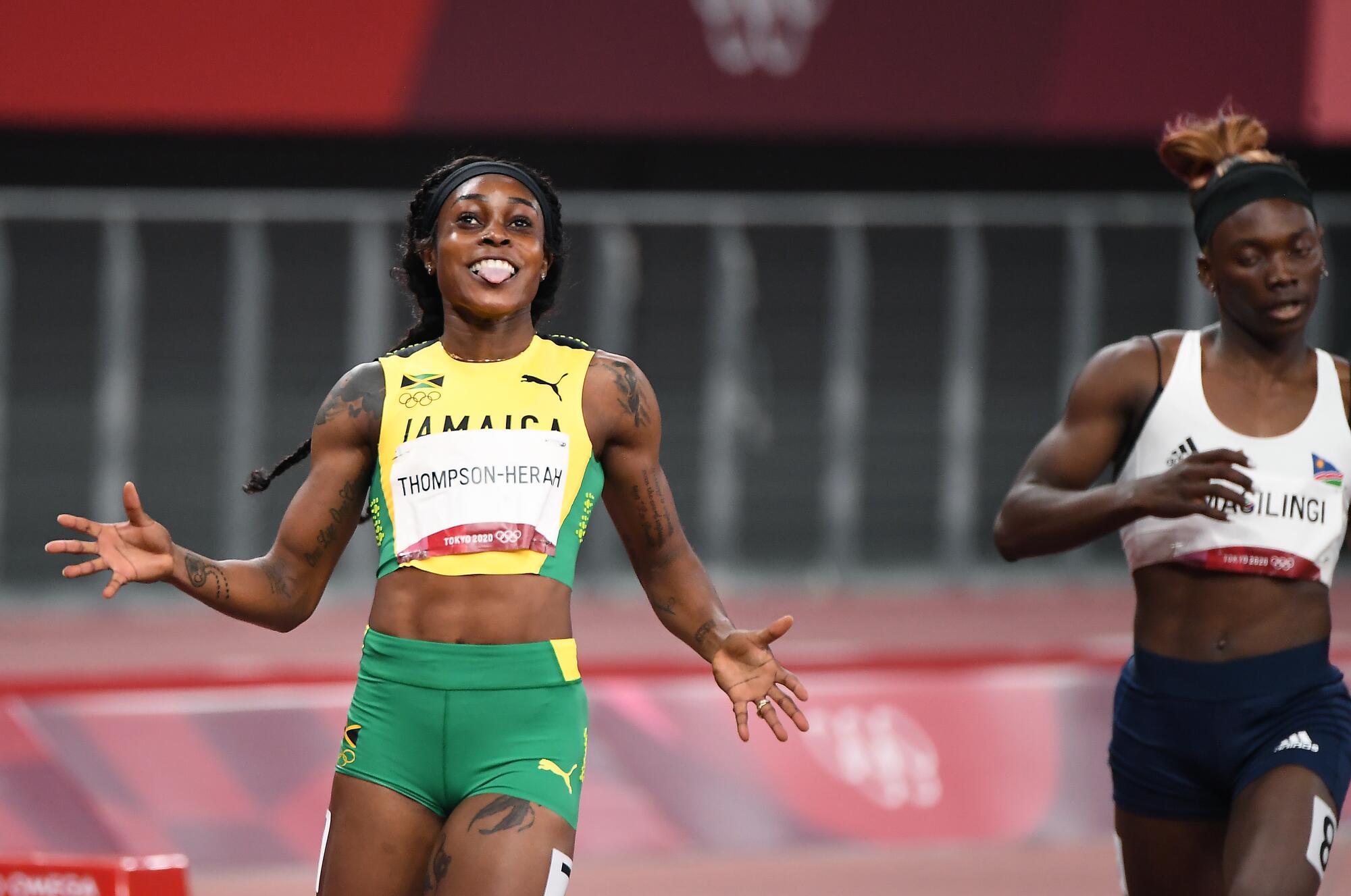Jamaica's Elaine Thompson-Herah celebrates the gold medal as she crosses the finish line in the women's 200m.