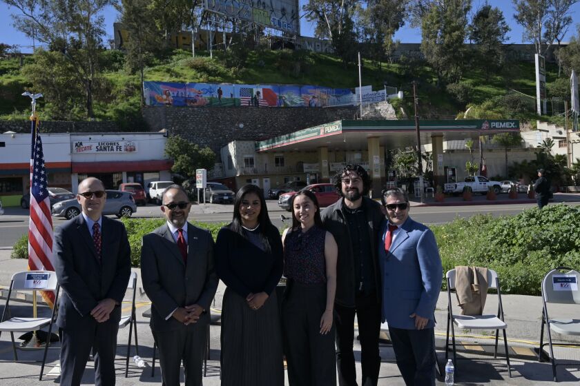 From left to right: Tom Reott, US Consul General in Tijuana, Carlos Gonzalez Gutierrez, Consul General of Mexico in San Diego with Tijuana Mayor Montserrat Caballero, Katya Echazarreta, scientist and first Mexican woman in space, Ivan Arevalo, art muralist and Santa Fe gas station owner Alejandro Borja pose for an official photo behind the new Tijuana bicentennial mural at a press conference on Tuesday, February 7, 2023. (Carlos Moreno / The San Diego Union-Tribune)