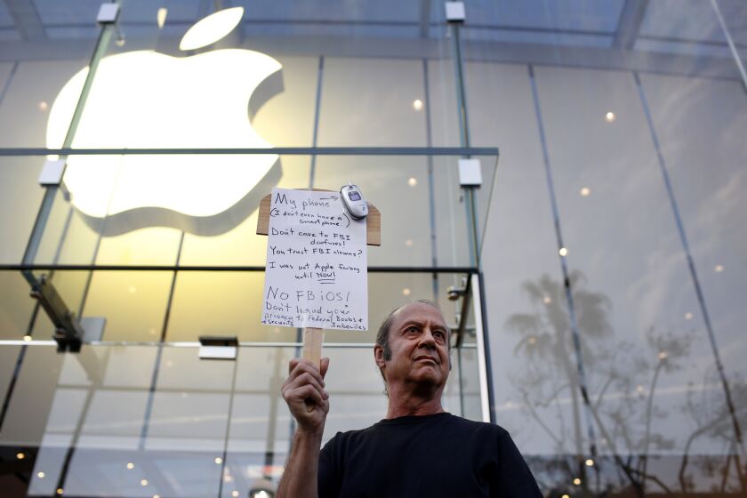 Joining a nationwide show of support, Tom Wolff holds a sign outside an Apple store in Santa Monica on Feb. 23 backing Apple's refusal to create software to circumvent security measures on a terrorist's phone.
