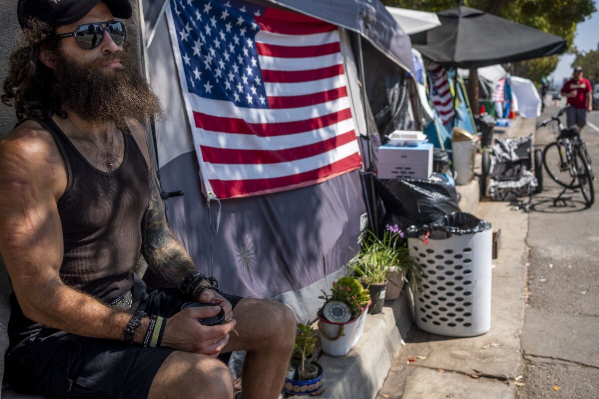 Jonathan Garcia sits next to his tent in a homeless encampment outside the West L.A. Veterans Affairs facilities.