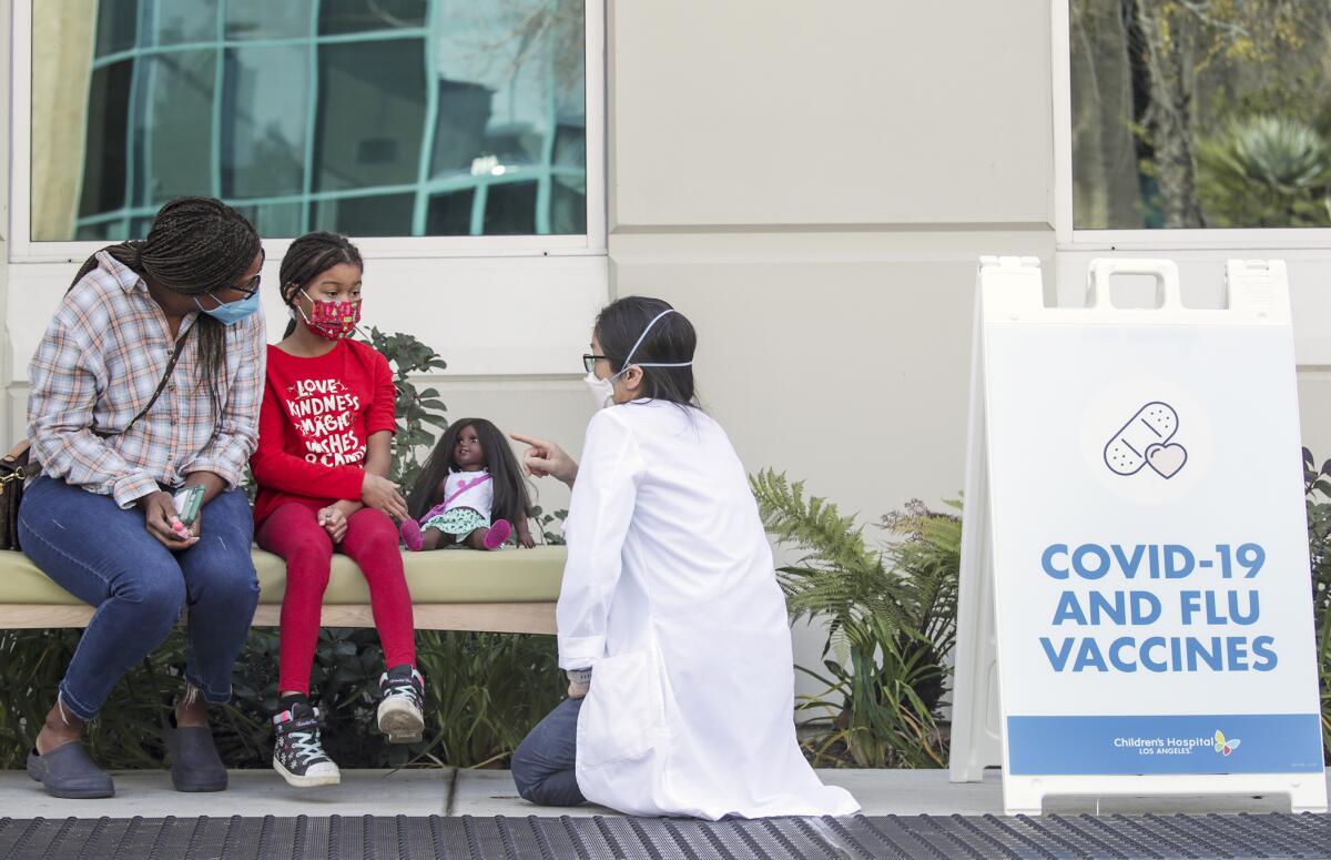 Dr. Susan Wu chats with Kimberli Samuel and her 7-year-old daughter outside.